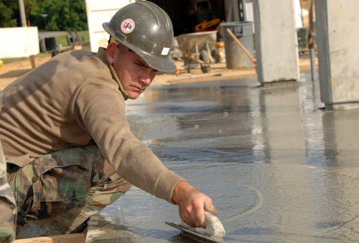 ouvrier qui applique du béton