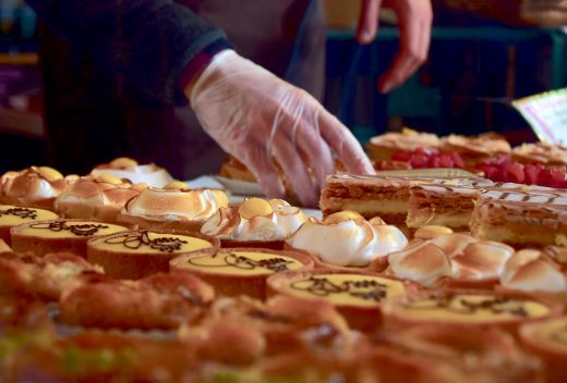 personne qui met des pâtisseries en vitrine