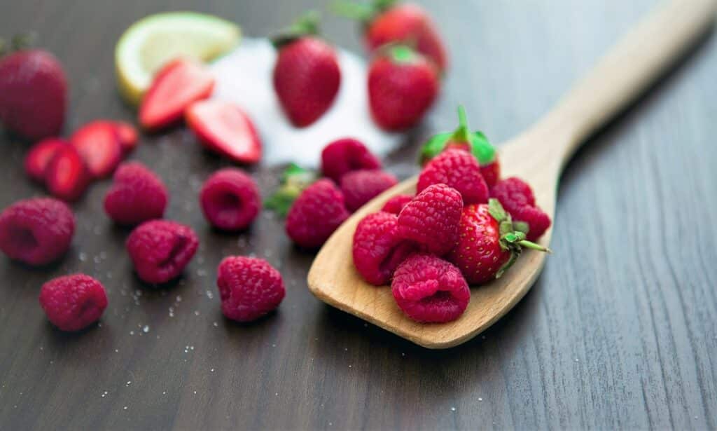 framboises et fraises sur une spatule en bois