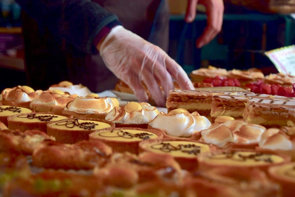 personne qui met des pâtisseries en vitrine